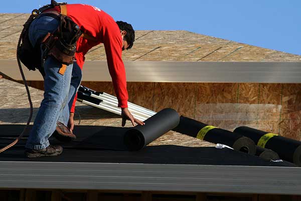 man working on installing a roof - okanagan exteriors